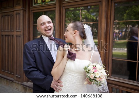 Bride pulling the tie of her fiance