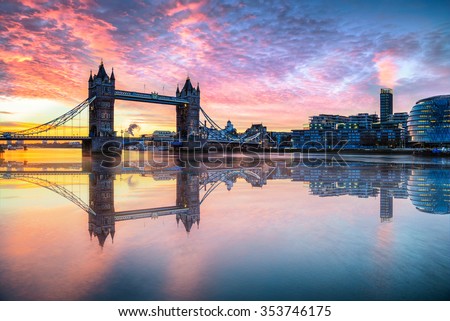 Tower Bridge with reflections at sunrise in London.