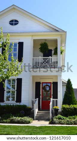 White Suburban American Cape Cod Home with Upstairs Balcony