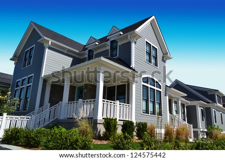 Grey New England Style Suburban Dream Home with Large Front Porch