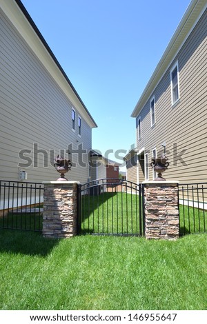 Fenced in Yard Between Two Brand New Suburban American Dream Homes