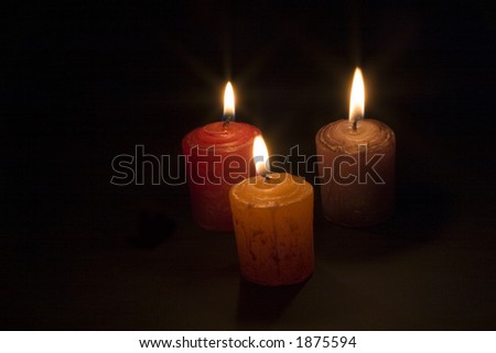 three candles burning in the dark