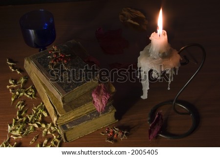 old wax candle and books with leaf