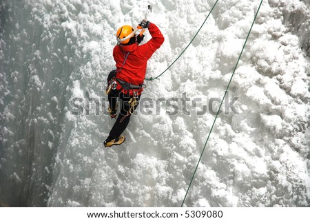 An Ice Climber going up a frozen waterfall.