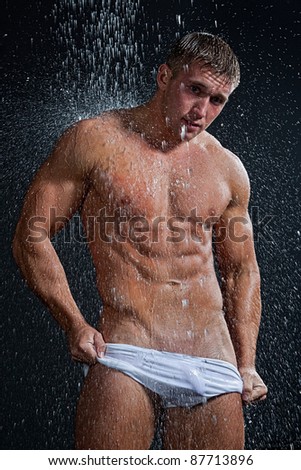 stock photo Muscle wet sexy young naked boy in white shorts posing under 