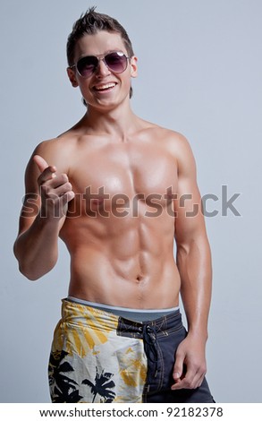 stock photo The muscular young naked smiling sexy boy in the beach shorts 