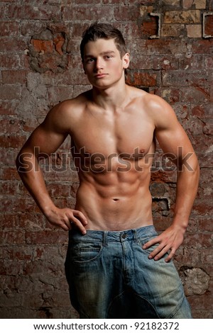stock photo Muscular young naked sexy boy posing in blue jeans on the 