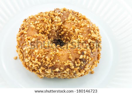 An hazelnut donut on the white plastic plate.