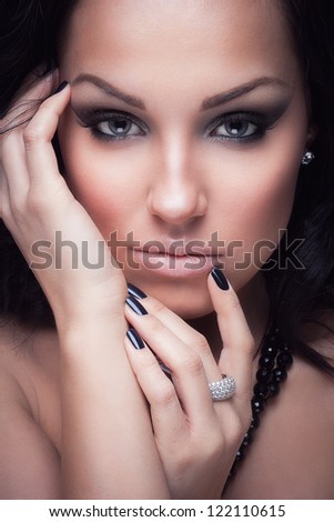 Portrait of a glamorous brunette girl with evening make up and long lashes