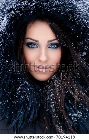 Young woman in a snowy furry hood