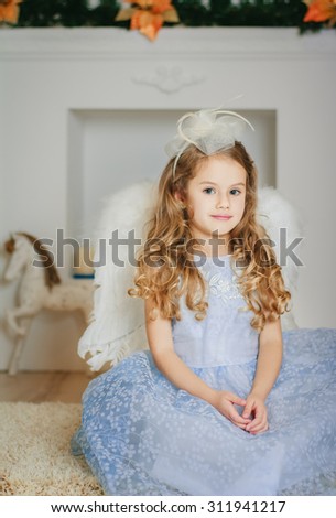 Little angel in light blue dress waiting Christmas.Studio shot