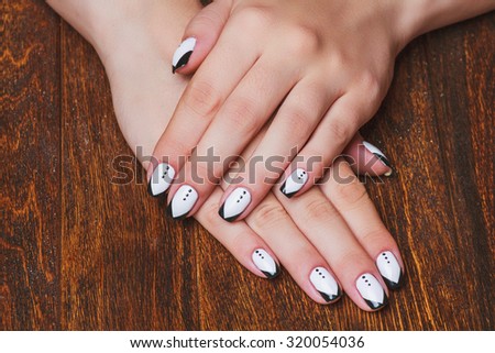 Black and white  nail art on dark wooden background