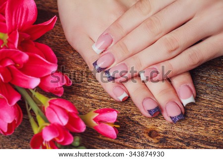 French nail art in purple color on wooden background