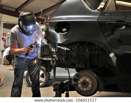 Car body worker welding car body.