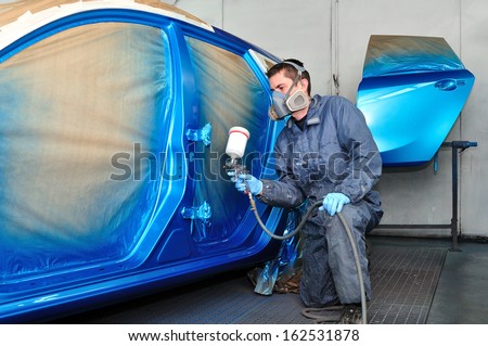 Profesional car painting in a paint booth.