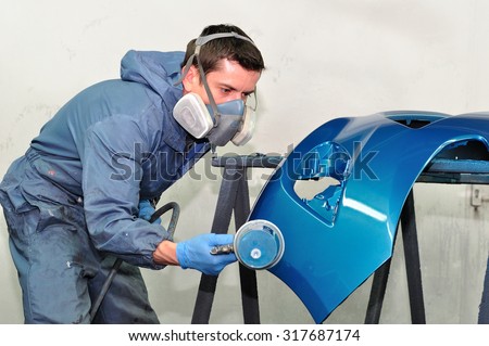 Professional car body repair, Painting blue bumper.