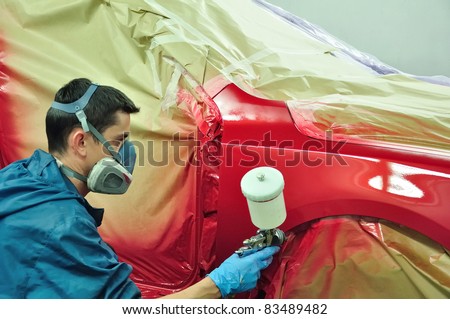 Man painting a red car.