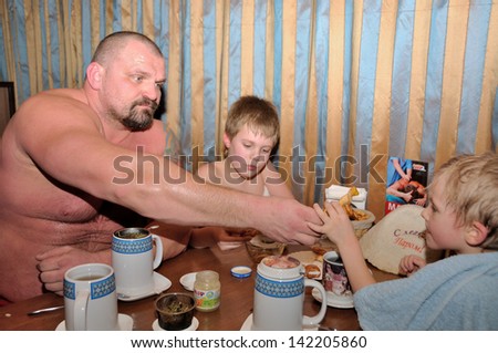 KIEV, UKRAINE - 20 MARCH 2013: The World\'s Strongest Man Vasyl Virastuk has a dinner with sons (Adam and Oleg) after sauna on March 20, 2013 in Kiev, Ukraine.