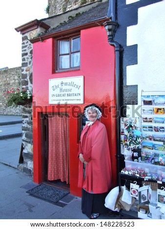 CONWAY, GREAT BRITAIN - CIRCA AUGUST 2007: Unknown woman stands near  the smallest house in Great Britain on August 2007 in Conway, Great Britain.