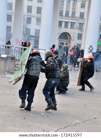 KIEV, UKRAINE - 20 JANUARY 2014: Unknown demonstrators run under police fire during street fight in government district on January 20, 2014 in Kiev, Ukraine.