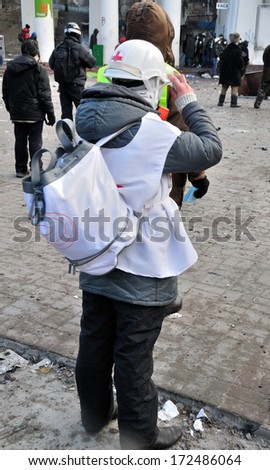 KIEV, UKRAINE - 20 JANUARY 2014: Unknown volunteer from Red Cross work during street fight in government district on January 20, 2014 in Kiev, Ukraine.