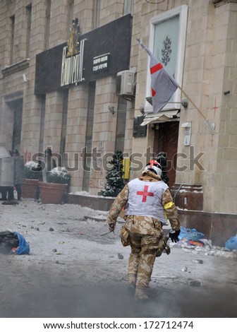 KIEV, UKRAINE - 22 JANUARY 2014: Unknown volunteer from Red Cross works during street fight in government district on January 22, 2014 in Kiev, Ukraine.