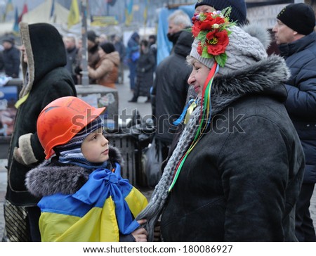 KIEV, UKRAINE - 16 FEBRUARY 2013: Unknown woman talks with boy during street fights with police in government district on February 16, 2013 in Kiev, Ukraine.