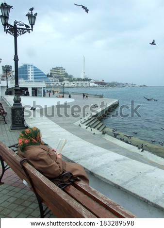 UKRAINE, SEVASTOPOL Ã¢Â?Â? CIRCA MAY 2010: Unknown grandmother reads a political newspaper at sea embankment circa May 2010 in Sevastopol, Ukraine.