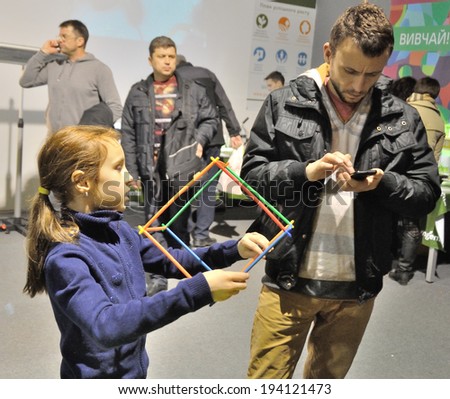 KIEV, UKRAINE - CIRCA APRIL 2014: Unknown children play with mind toys on the art and book exhibition in Arsenal museum circa April 2014 in Kiev, Ukraine