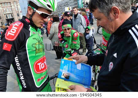 DONETSK, UKRAINE - CIRCA MAY 2013: Cyclists from Konya Torku Seker Spor read the sport journal after competition The Grand Prix of Donetsk on May 2013 in Donetsk, Ukraine.