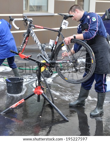 DONETSK, UKRAINE - CIRCA MAY 2013: Unknown mechanic of Russian team washes and prepares bicycles to race on May 2013 in Donetsk, Ukraine.