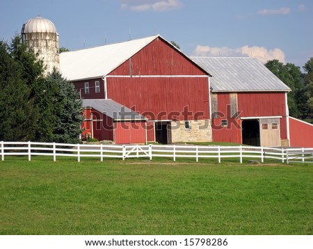 Red barn, white fence, and a silo.