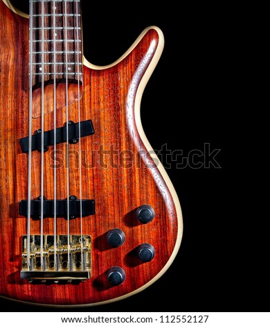 bass guitar from red textured wood with five strings close up isolated on black background