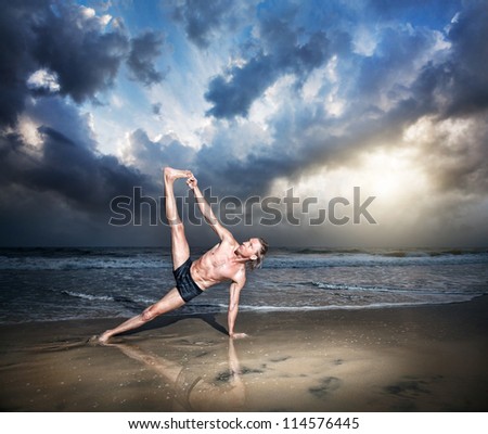 Yoga vasisthasana side plank pose by fit man on the beach near the ocean at sunset background