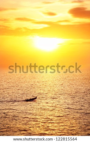 Fisherman boat catching fish in the ocean at sunset sky background in Kerala, India