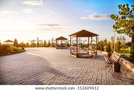 Summer houses with benches at sunset sky background in dendra park of first president Nursultan Nazarbayev in Almaty, Kazakhstan