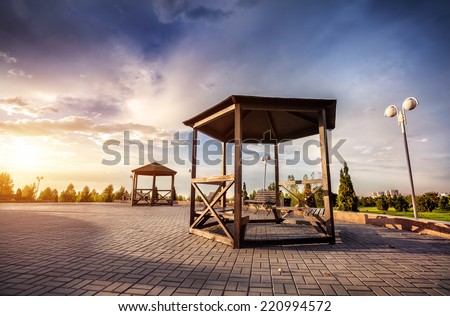 Summer houses with benches at sunset sky in dendra park of first president Nursultan Nazarbayev in Almaty, Kazakhstan