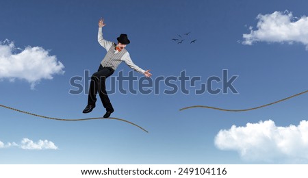 Ropewalker in black hat standing on broken rope in the blue sky with clouds