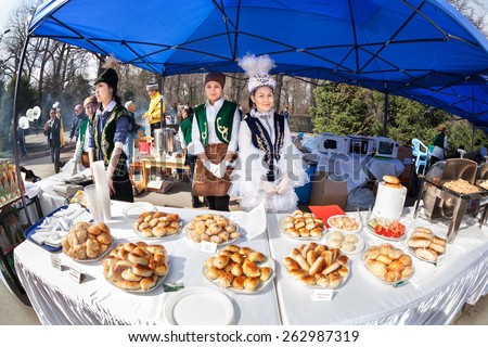 ALMATY, KAZAKHSTAN - MARCH 22, 2015: Women in national Kazakh costumes selling food at Nauryz celebration in Panfilov Park