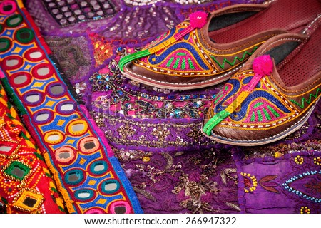 Colorful ethnic shoes, cushion cover and Rajasthan belts on flea market in India