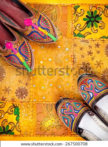 Colorful ethnic shoes on yellow Rajasthan cushion cover on flea market in India