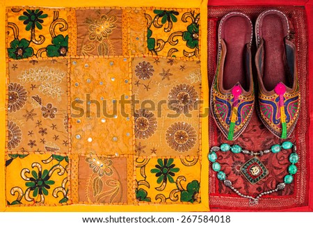 Colorful ethnic shoes, necklace and yellow Rajasthan cushion cover on flea market in India