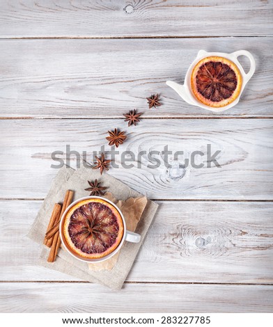 Moroccan tea with spices and slice of orange on the white wooden background