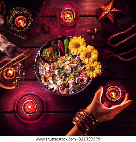 Vegetarian biryani, candles, incense and religious symbols at Diwali celebration on the table