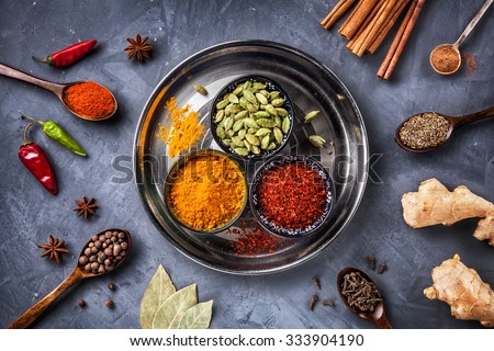 Various Spices like turmeric, cardamom, chili, bayberry, bay leaf, paprika, ginger, cinnamon, cumin, star anise and clove on grunge background
