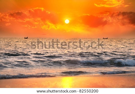 Two Fisherman boats catching fish in the ocean at sunset dramatic sky background in Kerala, India
