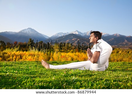 Yoga meditation eka pada shirasana foot behind the head pose by concentrate Indian Man in white cloth in the morning at mountain and blue sky background. Free space for text