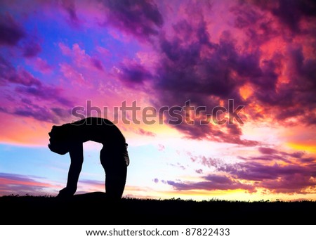 Yoga ushtrasana camel pose by man silhouette with purple dramatic sunset sky background. Free space for text and can be used as template for web-site