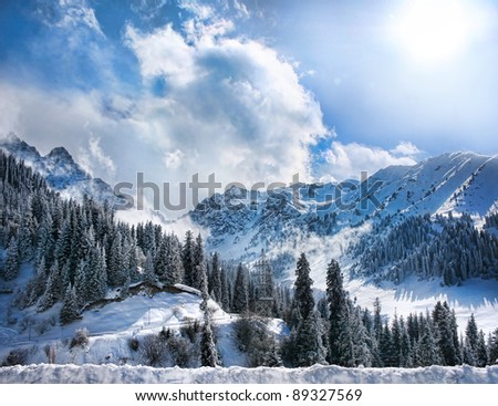 Winter Snowy Mountains valley with fog and sun in Chumbulak, Almaty, Kazakhstan