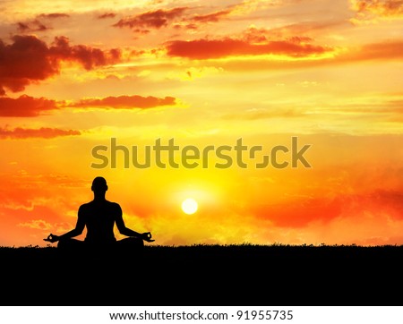 Yoga meditation in lotus pose by man silhouette at sunset sky background. Free space for text and can be used as template for web-site